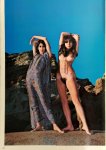 Nude woman standing beside draped woman on cliff